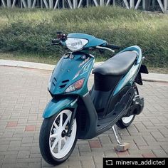 a blue scooter is parked on the sidewalk