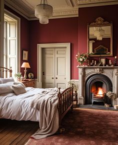 a bedroom with red walls and a fireplace