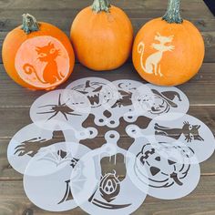 some pumpkins are sitting on a wooden table with stickers in the shape of animals