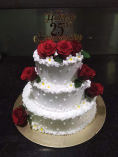 a three tiered white cake with red roses on top