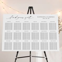 the seating chart for an event is displayed on a easel with lights in the background