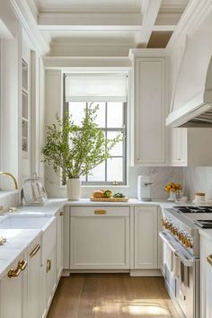 a kitchen filled with lots of white cabinets and counter top space next to a window