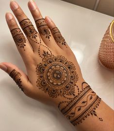 a woman's hand with henna tattoos on it