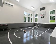 an indoor basketball court is shown in the middle of a room with high ceilings and large windows