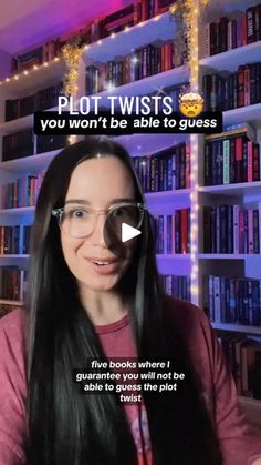 a woman with long black hair and glasses is talking to someone in front of bookshelves