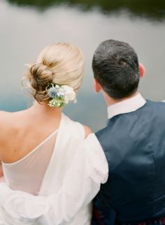 a bride and groom looking at the water