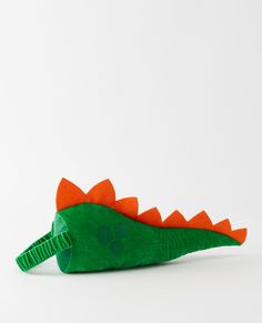 an orange and green stuffed alligator on a white background