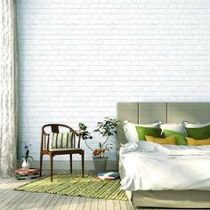 a bedroom with a bed, chair and brick wall in the background as well as a potted plant