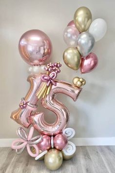 the number five balloon arrangement is pink, gold and white