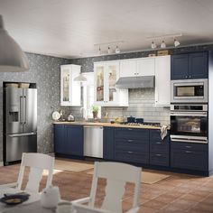 a kitchen with blue cabinets and white chairs is pictured in this image from the front view