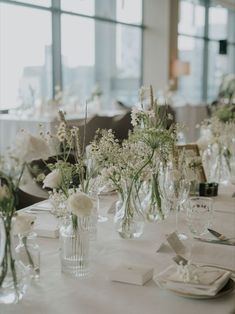 there are many vases with flowers in them on the table at this wedding reception