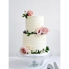 a three layer white cake with pink flowers on top