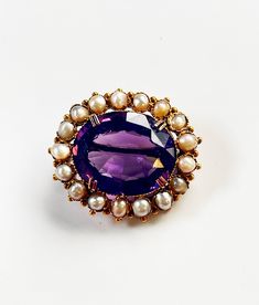 Beautiful antique brooch from the Victorian period. The natural Amethyst (1.8 x 1.2 cm) has a beautiful purple color and sparkles beautifully, because it is very well cut. Surrounded by 18 seed pearls. The whole is set in 18K gold. Not hallmarked, but tested and therefore guaranteed by us. A beautiful brooch to wear on many occasions. Dimensions: 2.7 x 2.2 cm. Weight: 6.60 grams. Purple Brooch, Wedding Brooches, Gold And Purple, Victorian Period, Gold Brooch, Wedding Brooch, Antique Brooches, Gold Brooches, Seed Pearl