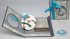 a snowman ornament in a card with a blue ribbon on it's head