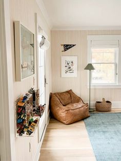 a living room with a brown bean bag chair and blue area rug on the floor