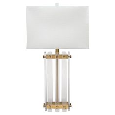 a lamp with a white shade on it and a gold frame around the light fixture