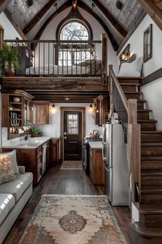 a living room and kitchen area in a home with wood floors, white walls and ceilings