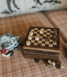 a wooden checker board sitting on top of a couch next to a stuffed animal