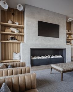 a living room filled with furniture and a flat screen tv mounted on the wall above a fire place