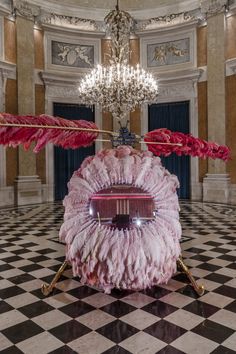 a large pink object sitting on top of a black and white checkerboard floor