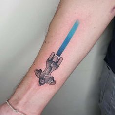 a tattoo on the arm of a man with a blue light saber in his hand