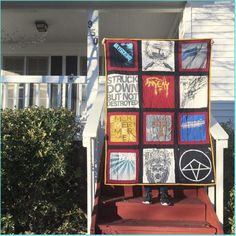 a person standing on the steps holding up a quilt