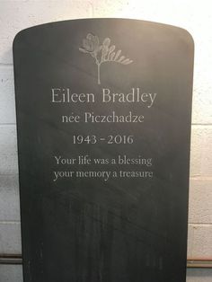 a memorial plaque is displayed in front of a brick wall