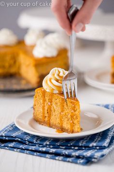 someone is holding a fork over a slice of pumpkin cheesecake with whipped cream on top