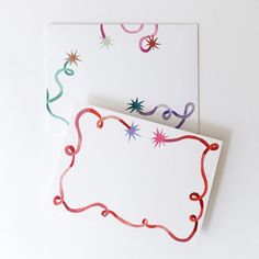 two greeting cards with red, white and blue ribbons on them are next to each other