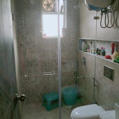 a bathroom with a toilet, shower and sink in it's own stall area