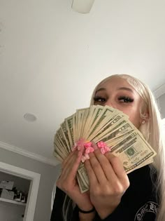 a woman covering her face with money