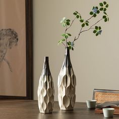 two vases sitting on top of a wooden table