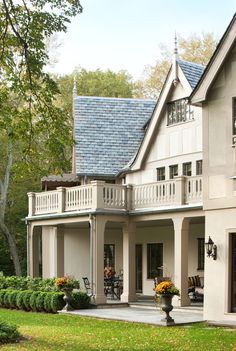 a large white house sitting on top of a lush green field