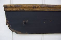 an old wooden sign hanging on the side of a white door with rusted paint