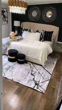 a bedroom with black and white decor on the walls, wood flooring and a chandelier hanging from the ceiling