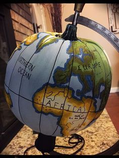 an earth globe on a stand in front of a fireplace