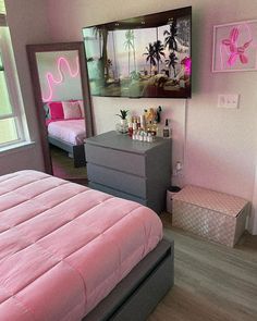 a bedroom with pink bedding and pictures on the wall