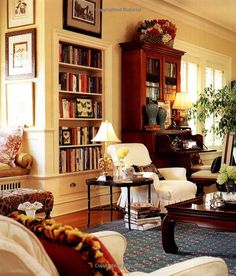 a living room filled with lots of furniture and bookshelves covered in pictures on the wall