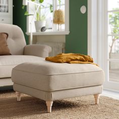 a white ottoman sitting on top of a rug in a living room