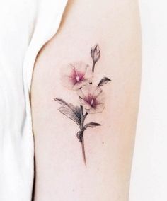 a close up of a flower tattoo on the left arm