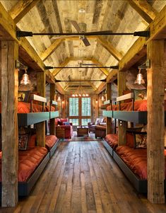 bunk beds are lined up in the middle of a room with wooden walls and ceilings