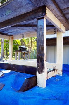 a wooden structure with blue tarp covering it