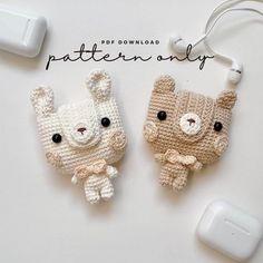 two crocheted animals sitting next to each other with ear buds on the side