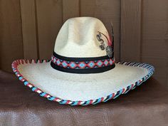 The Chippewa Gus Palm Hat has a 4" brim and 5 1/2" crown. Hand laced in black, turquoise and red leather lace. Beautiful turquoise beaded hatband is layered over black suede and the back of the band has a deer antler bead for accent. Accented with multiple Conchos and a black feather tipped with silver. Best Seller! All hats are made to order. Allow up to 4 weeks for your hat to ship. Antler Beads, Talc Powder, Hat Holder, Cloth Tape, Sweat Stains, Black Turquoise, A Deer, Deer Antler, Cowgirl Hats