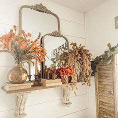 there is a shelf with flowers and mirrors on it