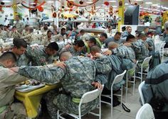 many soldiers are sitting at tables eating food