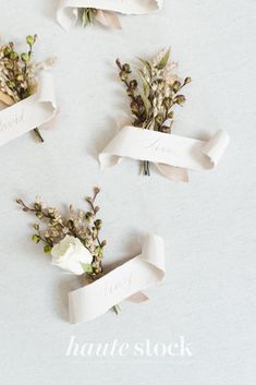 flowers are wrapped in white paper and placed on top of each other with name tags