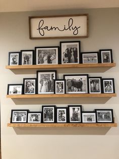 family pictures are arranged on wooden shelves in front of a sign that reads, family