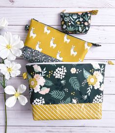 three zippered pouches with flowers and deers on them sitting next to each other