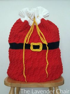 a crocheted santa sack sitting on top of a wooden chair